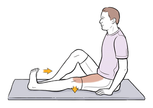 Man sitting on mat with one leg straight and one leg bent doing quadriceps sets.