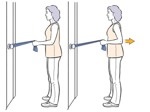 Woman doing standing rows exercise with an exercise band looped around a doorknob.